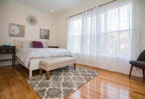 a bedroom with a bed and a window and a rug at Modern Townhome,boston Vacation,2 Bath,pkg,deck in Brookline