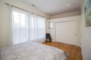 a bedroom with a bed and a large window at Modern Townhome,boston Vacation,2 Bath,pkg,deck in Brookline