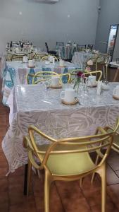 a long table with yellow chairs and white table cloth at Essencial Hotel & Spa in Mendoza