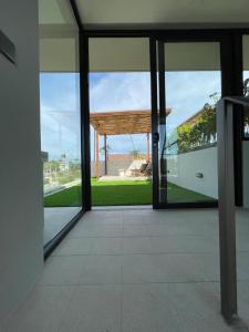 szklanymi drzwiami budynku z widokiem na ocean w obiekcie Luna Ola Villa Berawa w mieście Canggu