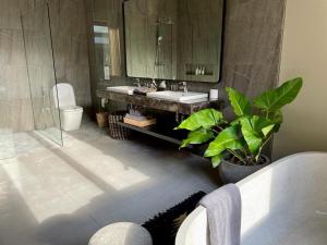a bathroom with a sink and a toilet and a mirror at Luna Ola Villa Berawa in Canggu