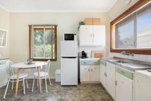 een keuken met een tafel en een witte koelkast bij The Peach Tree 2 Bed Home in Elizabeth