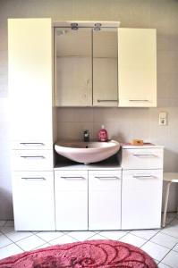 a bathroom with a sink and white cabinets at Ferienwohnung Eudenbach in Alsbach