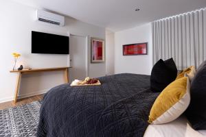 um quarto com uma cama grande e uma televisão na parede em Lancefield Luxury Guest Suite - DoubleDare em Lance Field