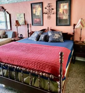 a bedroom with a bed with a red comforter at Shamrock Cove Inn in Ocala