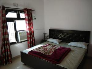 1 dormitorio con 1 cama en una habitación con ventanas en Goroomgo Riddhi Siddhi Haridwar Near Railway Station - Best Seller en Haridwār