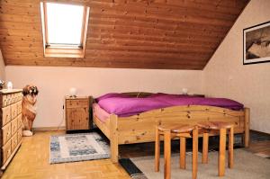 ein Schlafzimmer mit einem Bett, einem Tisch und einem Hund in der Unterkunft Ferienwohnung Eudenbach in Alsbach