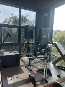 una sala de grabación con sillas, TV y ventanas en Hotel Stylish Binh Long, en Thanh Bình
