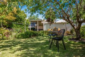 a table and chairs under a tree in a yard at Arden Monte Vista in Rye
