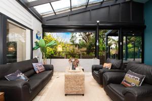 - un salon avec des canapés en cuir noir et une table dans l'établissement Blue Haven Pet Friendly Retreat, à McCrae