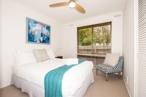 een witte slaapkamer met een bed en een raam bij Blue Haven Pet Friendly Retreat in McCrae