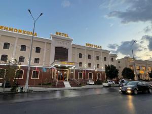 un coche está conduciendo delante de un hotel en Zilol Baxt Hotel, en Samarkand