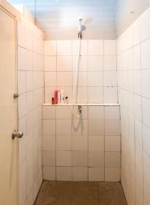 a bathroom with a shower with white tiled walls at Artwork house good cozy apartment in Bang O