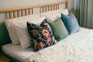 uma cama com várias almofadas em cima em Artwork house good cozy apartment em Bang O