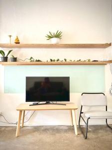 sala de estar con TV, mesa y sillas en Artwork house good cozy apartment en Bang O