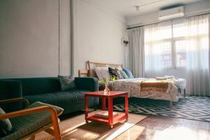 a living room with a green couch and a bed at Artwork house good cozy apartment in Bang O