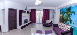 uma sala de estar com um sofá roxo e uma televisão em Sophia 2 & Moonlight Apartaments em Mamaia