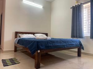 a bed in a room with a blue blanket on it at Kamlax Villa Near Serenity Beach at puducherry in Puducherry