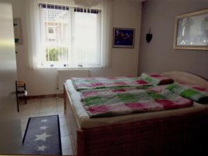 a bedroom with a bed with a quilt on it at Seebergweg Modern retreat in Maasholm-Bad