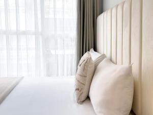 a bedroom with a bed with two pillows and a window at urban abode apartments in Taipei