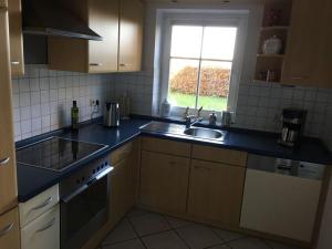 uma cozinha com um lavatório, um fogão e uma janela em Nordglück Modern retreat em Taarstedt