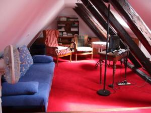 ein Wohnzimmer im Dachgeschoss mit einem blauen Sofa und Stühlen in der Unterkunft Cozy apartment on the canal in Friedrichstadt
