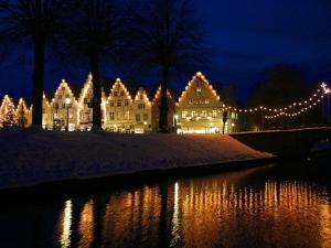 ein beleuchtetes Gebäude mit Weihnachtslichtern neben einem Fluss in der Unterkunft Cozy apartment on the canal in Friedrichstadt
