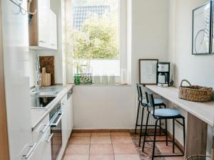 cocina con encimera con taburetes y ventana en Anchorage Modern retreat en Flensburg