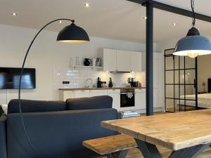 - un salon avec un canapé et une table en bois dans l'établissement Simmerdeis on the Gracht - Loft1, à Friedrichstadt