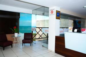 eine Lobby mit 2 Stühlen und einem Tisch mit Meerblick in der Unterkunft Marsallis Praia Hotel in Natal