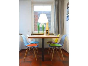 uma mesa com quatro cadeiras e um candeeiro em Christel Modern retreat em Langeoog