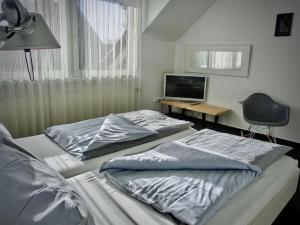 Habitación con 2 camas, escritorio y TV. en Christel Modern retreat, en Langeoog