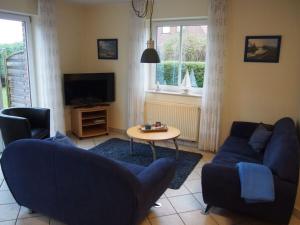sala de estar con sofá azul y mesa en Deichwiege Modern retreat, en Horumersiel