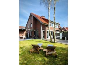 dos mesas de picnic en el césped junto a una casa en Christel Modern retreat, en Langeoog