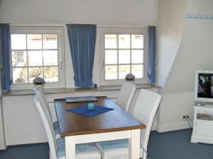 蘭圖姆的住宿－Haus Ruusenhoog - Apartment 7，一间带木桌和2扇窗户的用餐室