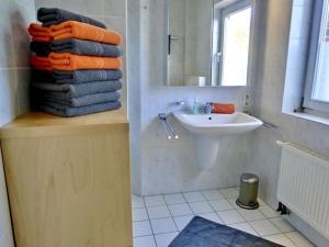 Un baño con un lavabo y una pila de toallas. en Christel Modern retreat, en Langeoog 34 fotos más