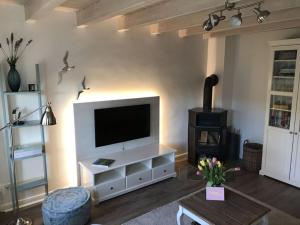 Una sala de estar con un televisor de pantalla plana en una pared. en Favorite place Modern retreat, en Wrixum