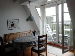 a dining room with a table and a balcony at Lagoon on the Wadden See on Wangerooge in Wangerooge +19 photos