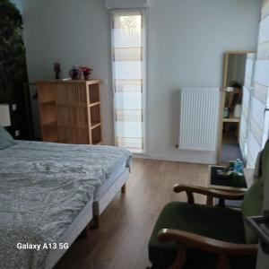 sypialnia z łóżkiem, krzesłem i lustrem w obiekcie Résidence l'estrade w mieście Dunkierka