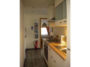 eine Küche mit Spüle und Herd Oberer Backofen in der Unterkunft North Sea dike Modern retreat in Sehestedt