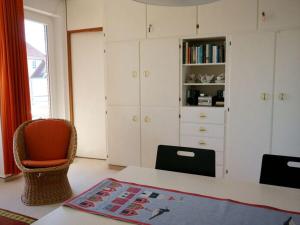 a bedroom with white cabinets and a table and chairs at near the beach Modern retreat in Wangerooge