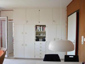 a large white cabinet with a lamp in a room at near the beach Modern retreat in Wangerooge