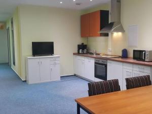 a kitchen with white cabinets and a table and a television at Country house Wachendorf in Bruchhausen-Vilsen