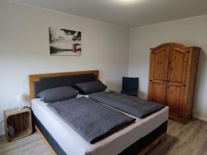 a bedroom with a bed and a wooden cabinet at Little Freedom Modern retreat in Friedrichsau