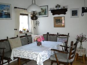 uma sala de jantar com uma mesa branca com flores em Strandnelke Modern retreat em Sehestedt