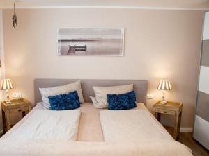 um quarto com uma cama grande e almofadas azuis em Porthole in the Seute Deern house em Juist