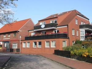 a red brick building with a clock on it at Porthole in the Seute Deern house in Juist
