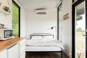 Habitación pequeña con cama y escritorio. en Forest View Cottage 1 en Jiaoxi
