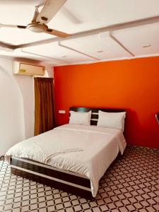 a bed in a room with an orange wall at Private 1Bedroom AC Kalyani Nagar Pune Close to Osho Garden Koregaon Park in Pune