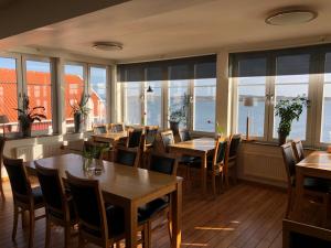 un restaurante con mesas, sillas y ventanas en ÖMC Kurshotell en Öckerö